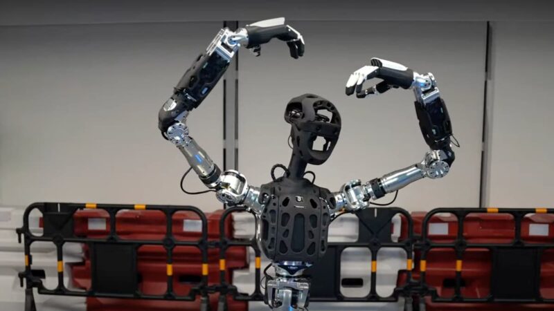 robotul Adam-u cu mainile deasupra capului