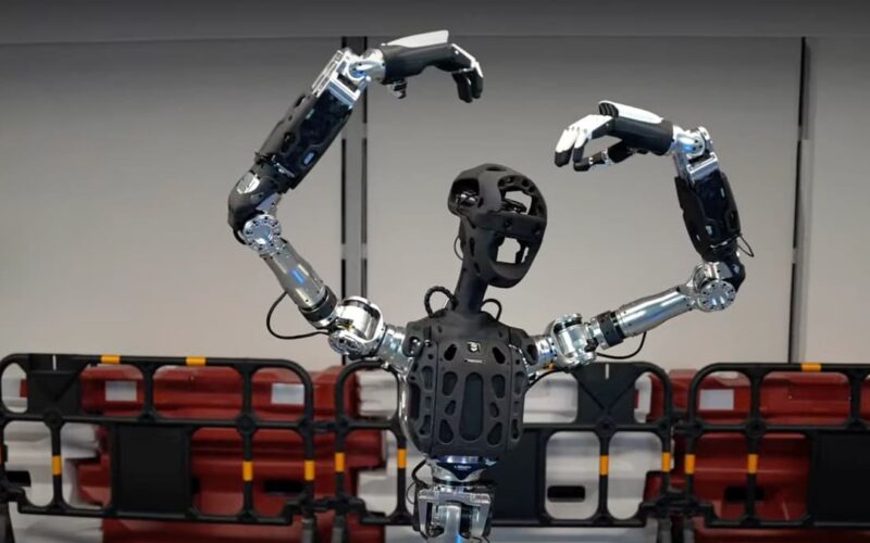 robotul Adam-u cu mainile deasupra capului