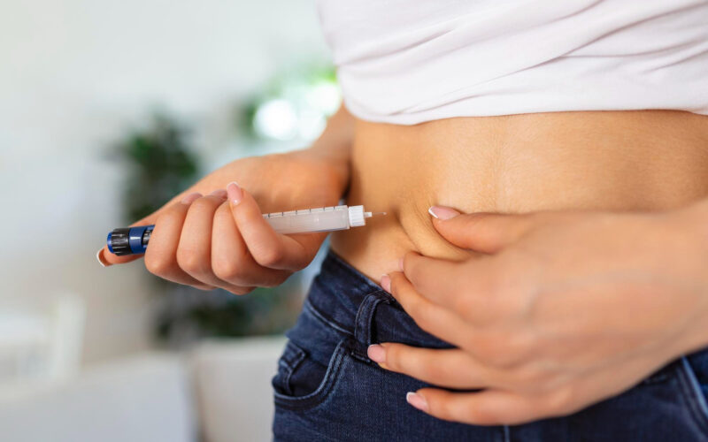 o femeie isi face o injectie cu insulina