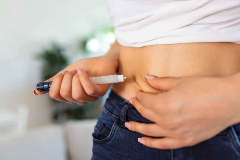 o femeie isi face o injectie cu insulina