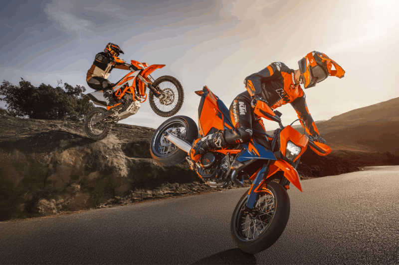 doua motociclete portocalii de la ktm fotografiate pe pista