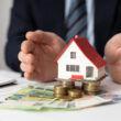 o imagine cu bani si o casa care ilustreaza o investitie in imobiliare
