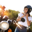 o femeie isi pune casca moto