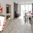 o mana care tine un telefon cu sigla AirBnb in interiorul unui apartament