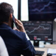 un investitor se uita la ecrane