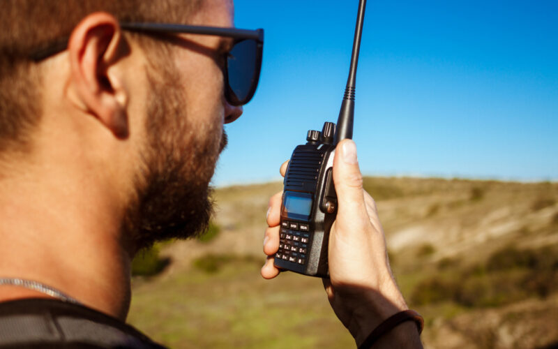 un barbat foloseste un walkie-talkie