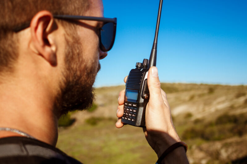 un barbat foloseste un walkie-talkie