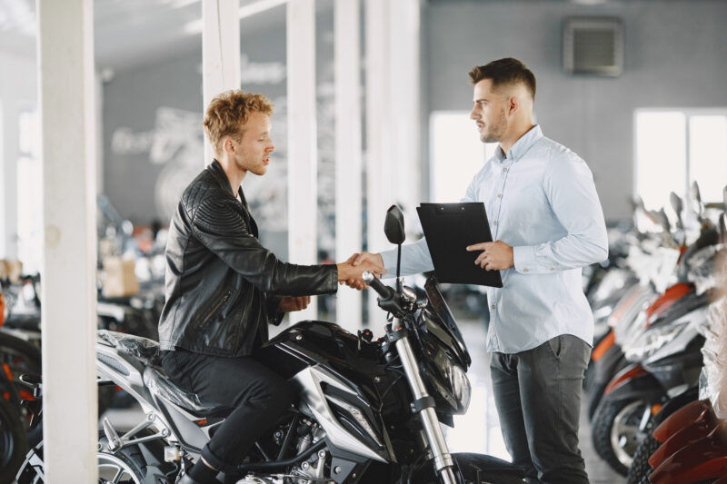 un client incearca o motocicleta la un dealer moto