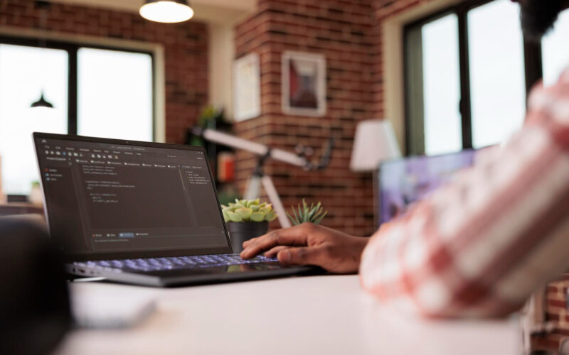 un programator lucreaza la un laptop