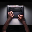 imagine cu mainile unui barbat care foloseste un laptop