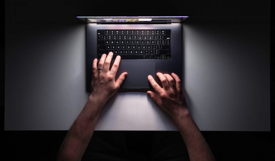 imagine cu mainile unui barbat care foloseste un laptop