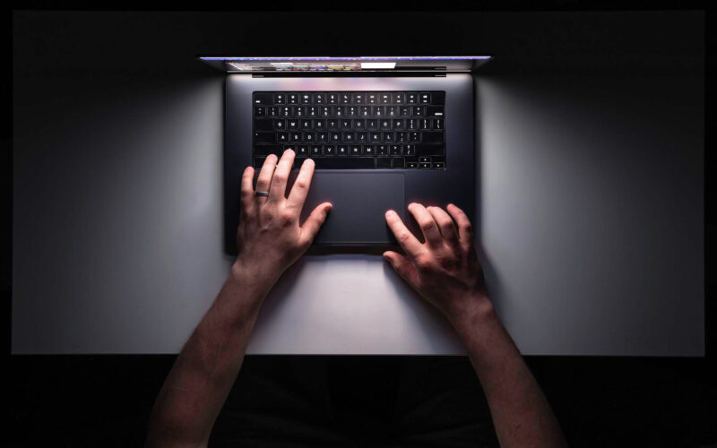 imagine cu mainile unui barbat care foloseste un laptop