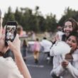 woman in white dress holding black smartphone