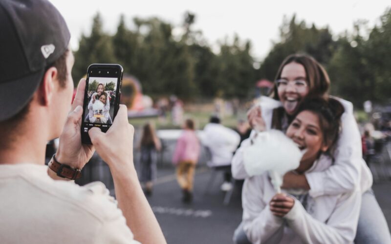 woman in white dress holding black smartphone