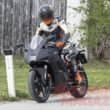 motocicleta neagra cu rider surprinsa pe strada