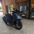 scuter albastru de la honda fotografiat in fata unei cafenele