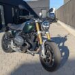 motocicleta retro de culoare verde cu fundal negru in spate