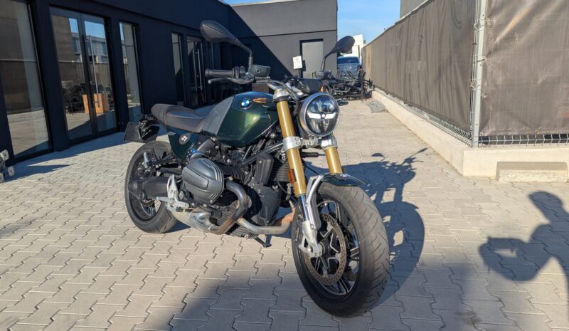 motocicleta retro de culoare verde cu fundal negru in spate
