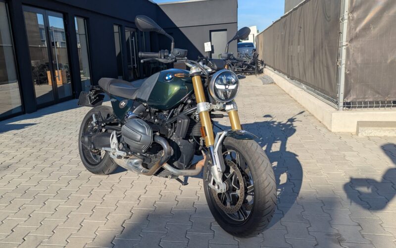 motocicleta retro de culoare verde cu fundal negru in spate