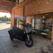 scuter gri de la yamaha fotografiat in fata unei cafenele