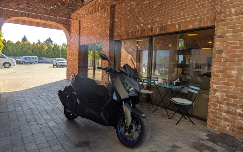 scuter gri de la yamaha fotografiat in fata unei cafenele