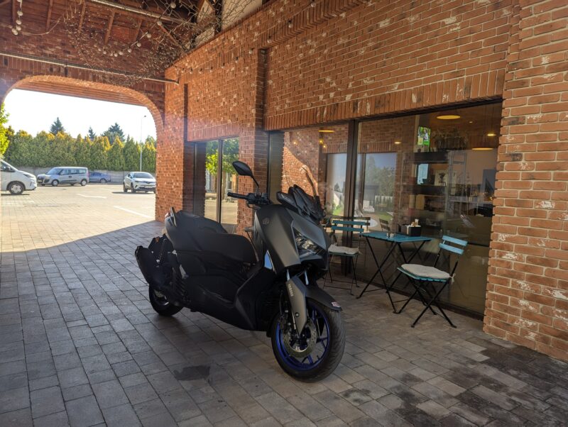 scuter gri de la yamaha fotografiat in fata unei cafenele