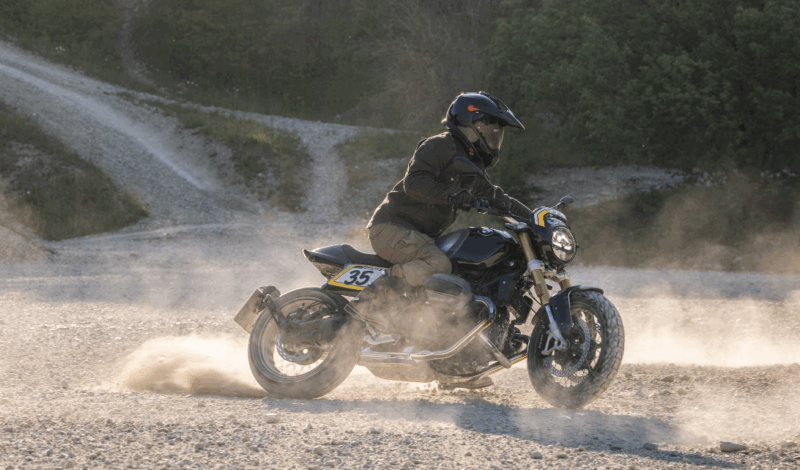 motocicleta clasica neagra pe teren accidentat