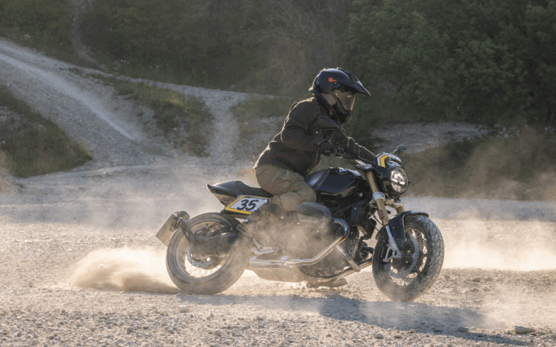motocicleta clasica neagra pe teren accidentat