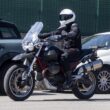 Motocicleta neagra adventure fotografiata in trafic