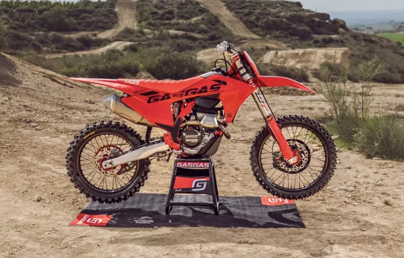 motocicleta enduro de culoare rosie fotografiata pe teren accidentat