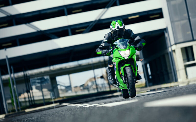 motocileta sport de culoare verde suprinsa intr-o parcare