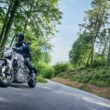 motocicleta honda electrica surprinsa pe un drum de munte intre copaci