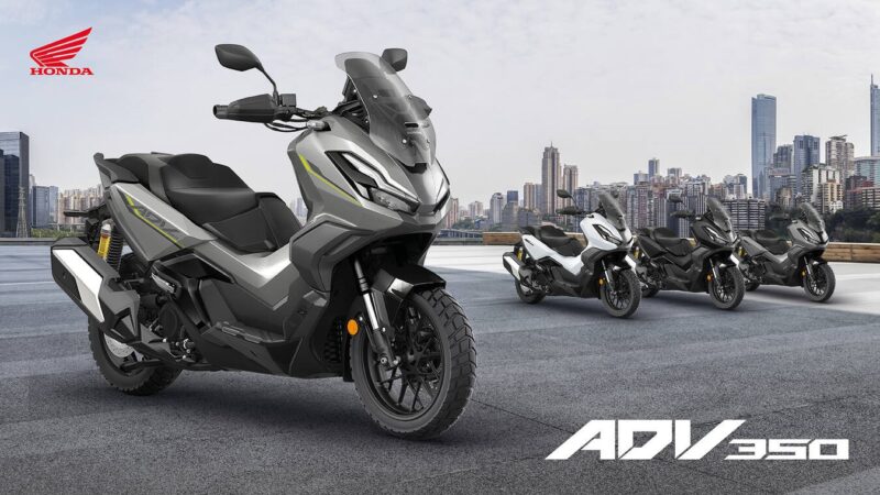 poster cu 4 scutere honda si cu un oras in fundal