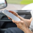 o femeie foloseste un telefon intr-o masina