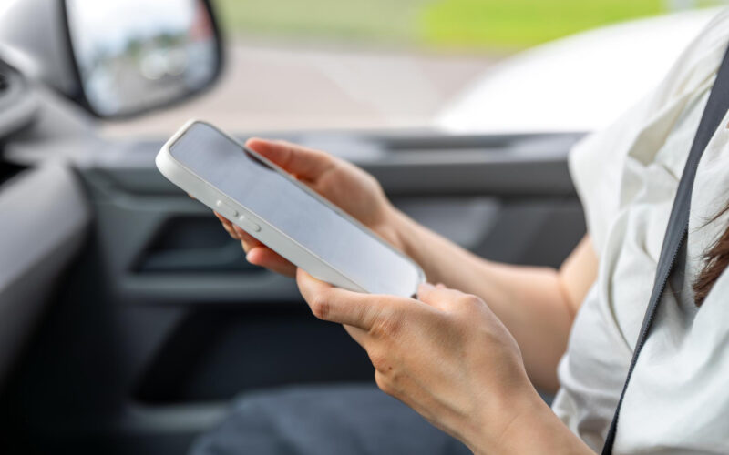 o femeie foloseste un telefon intr-o masina