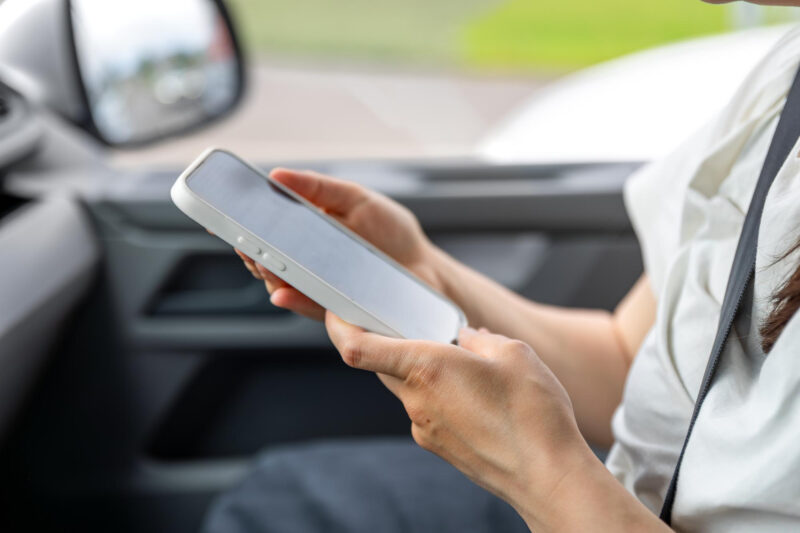 o femeie foloseste un telefon intr-o masina
