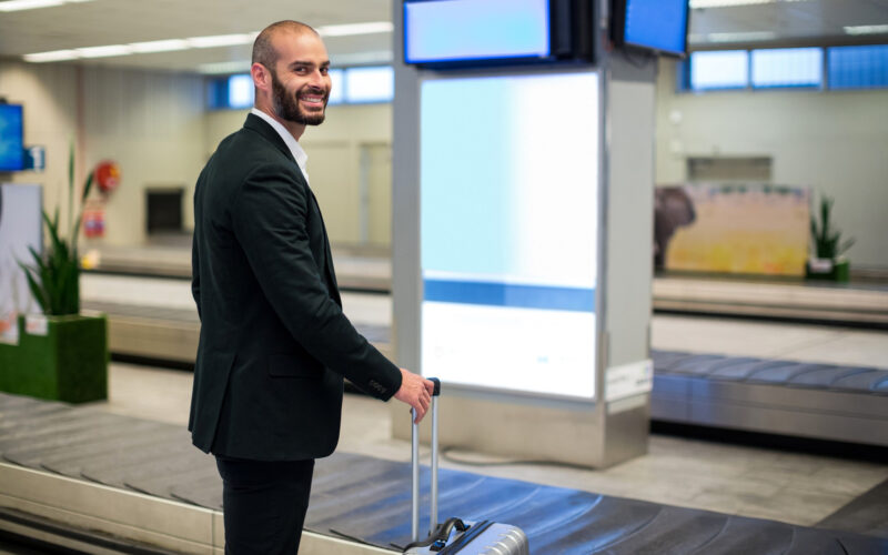un pasager se afla pe un aeroport la zona de recuperare bagaje