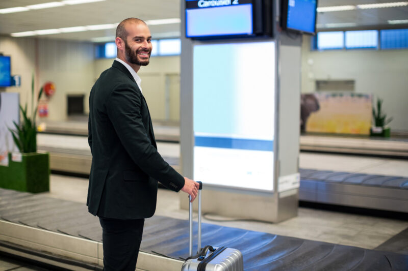 un pasager se afla pe un aeroport la zona de recuperare bagaje