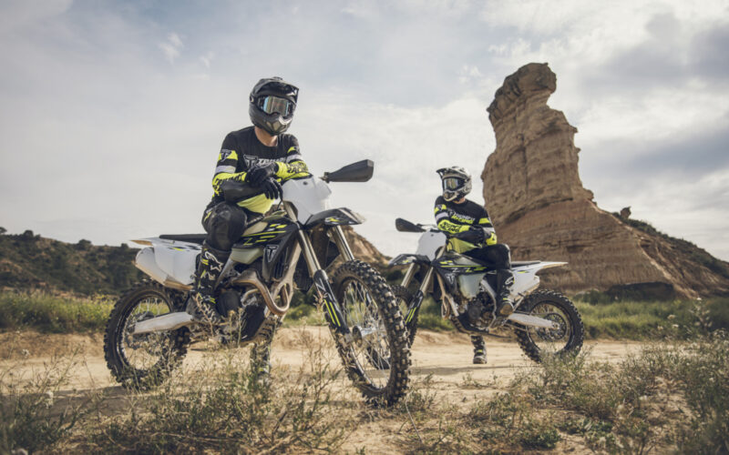 doua motociclete cross fotografiate pe teren accidentat