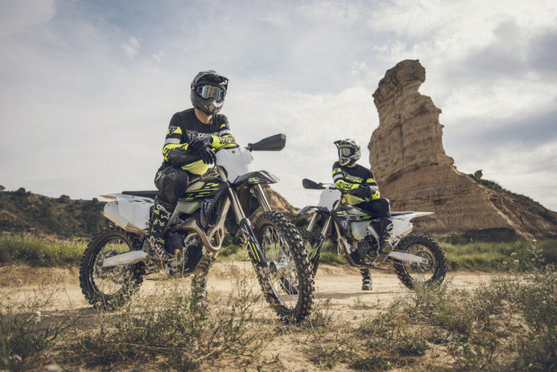 doua motociclete cross fotografiate pe teren accidentat