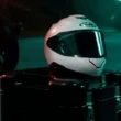 casca moto de culoare alba pusa peste un cufar