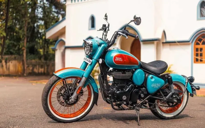 motocicleta royal enfield de culoare albastra in fata unei claridi