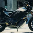 motocicleta electrica fotografiata pe strada in fata unei cladiri