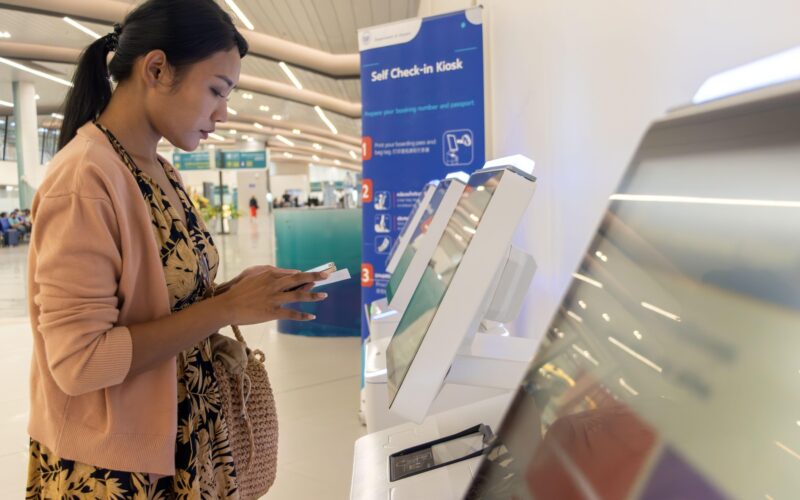 sistem de self check-in pe un aeroport folosit de o femeie