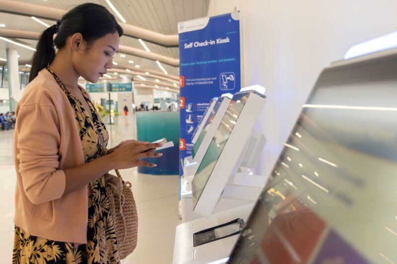 sistem de self check-in pe un aeroport folosit de o femeie