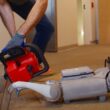 un barbat taie cu drujba picioarele unui robot pentru un experiment