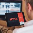 un barbat care se uita la netflix pe tableta