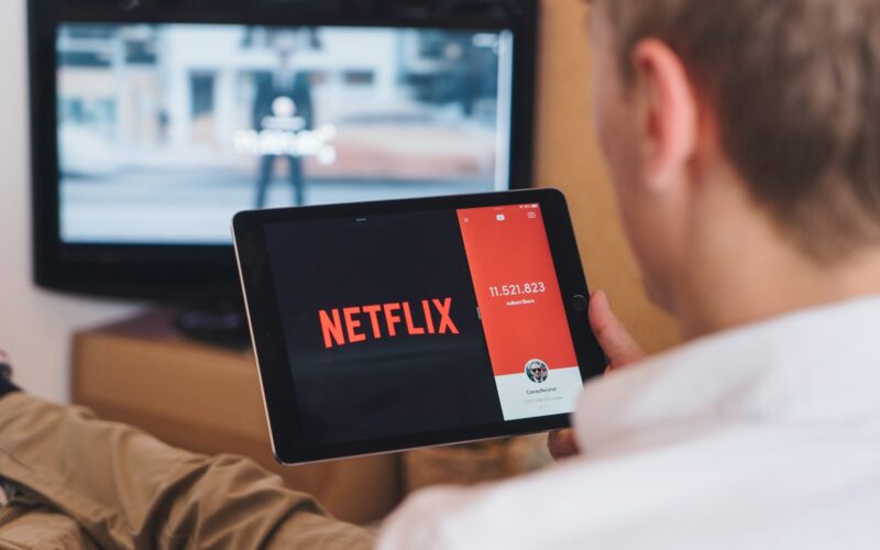 un barbat care se uita la netflix pe tableta