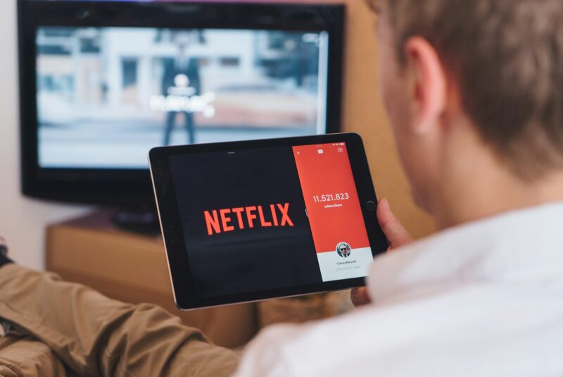 un barbat care se uita la netflix pe tableta