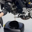 recipient negru ce colecteaza uleiul utilizat dintr-o motocicleta